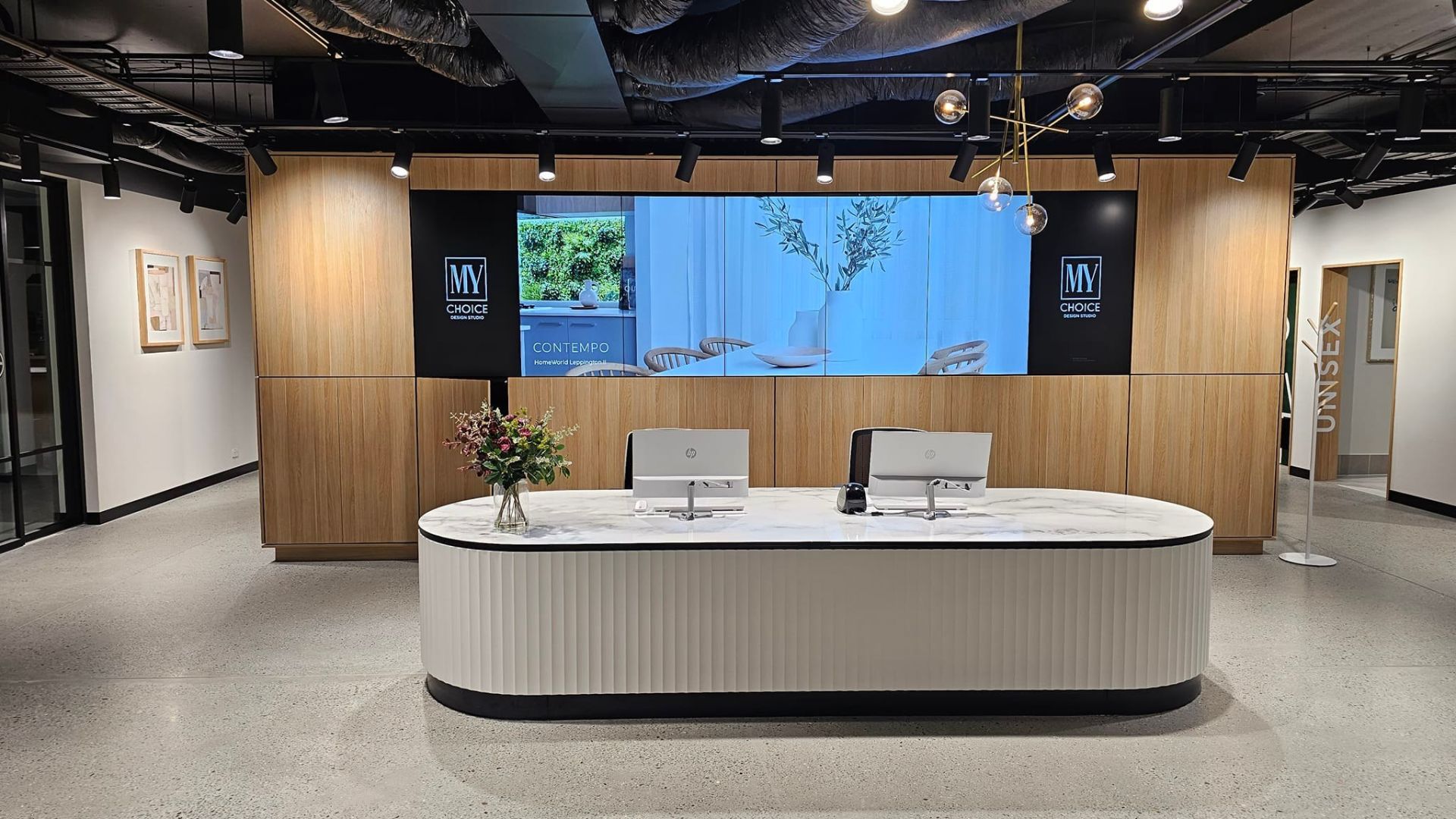 This image showcases the front desk of McDonald Jones Homes' flagship headquarters in Sydney, featuring power installations completed by Commercial Electrician Sydney.