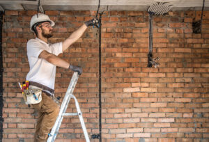 Electrician with tools, working on a construction site. Repair and handyman concept. House and house reconstruction.